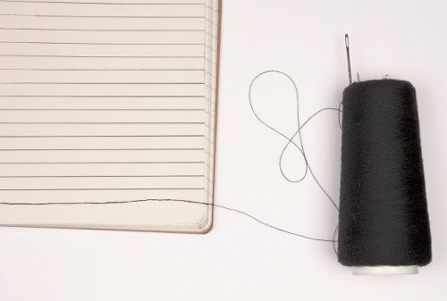 cuaderno sobre el que se cose una línea